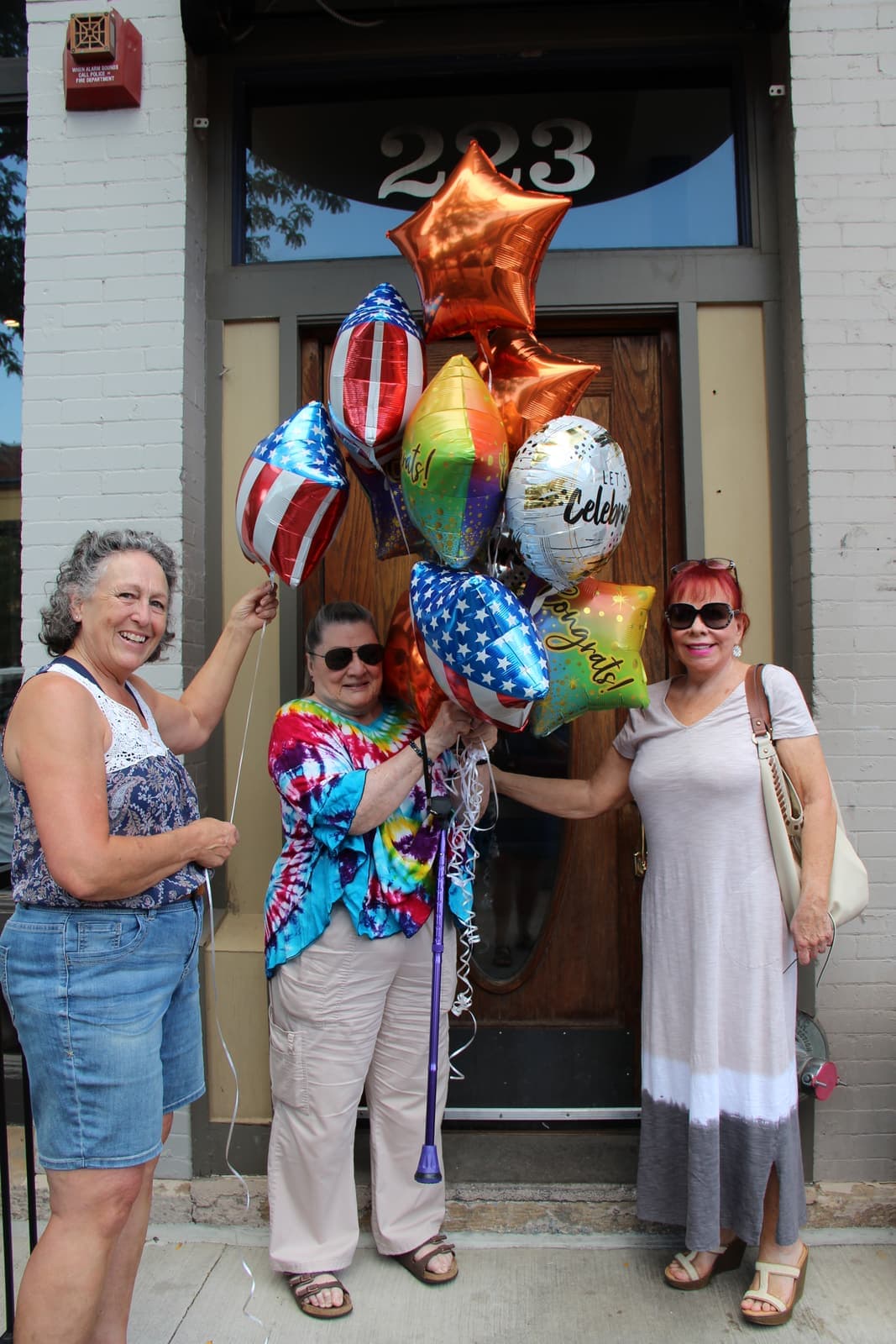 Guests celebrating with star and balloon bouquets outside the Old Town parlor