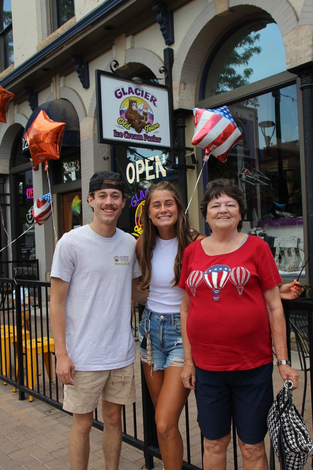 Family posing under the Glacier sign at the front door on opening day