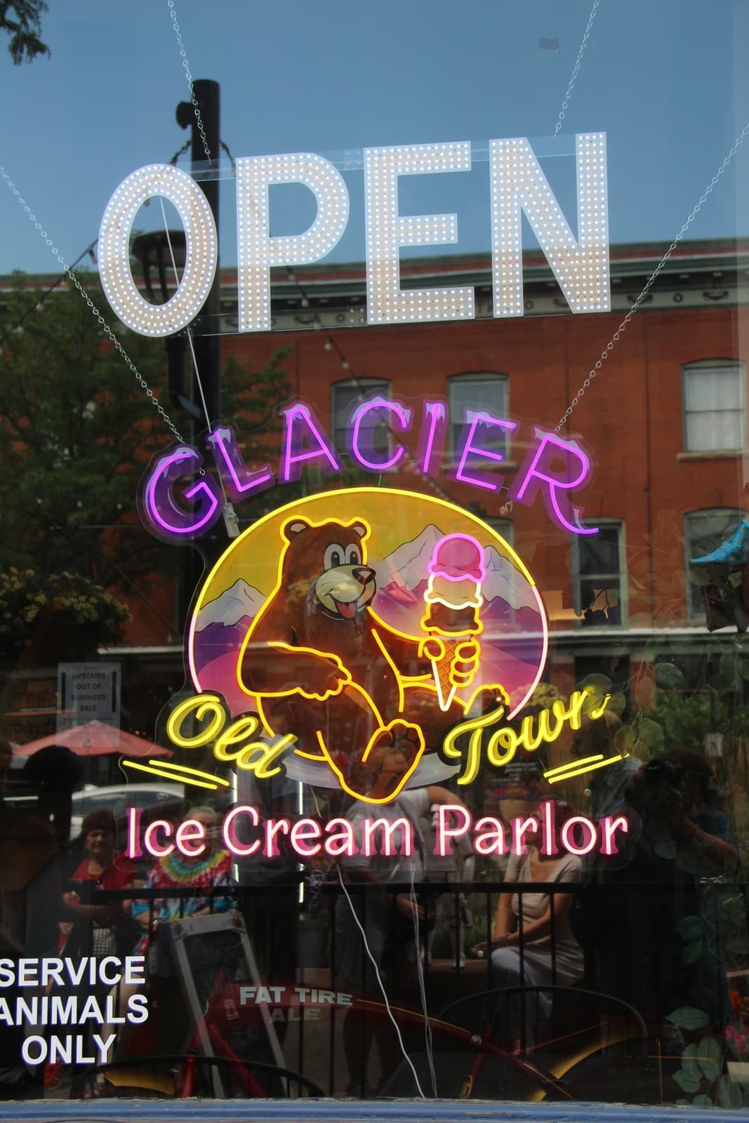The neon Glacier Old Town window sign glowing behind the OPEN letters